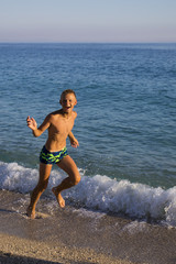 teenager running on the seashore.joy, fun, emotions.Summer vacation,