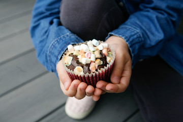 Kinderhand hält Marshmallow-Muffin