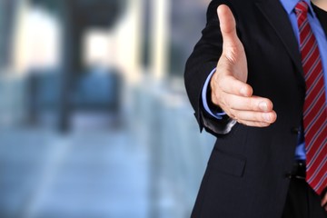 Man wearing a business suit reaching hand out
