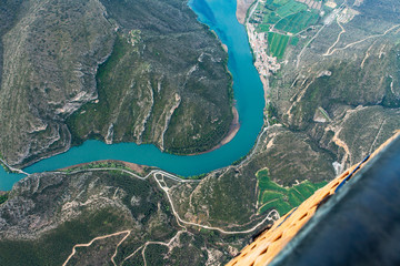 Aerial landscape photo of the river Riu Segre, Catalonia Spain. Corner of hot air balloon basket is visible, bottom right