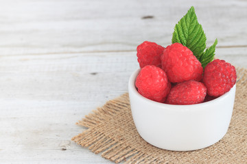 Raspberry in bowl. Raspberry on blue bacground with copy space for text.