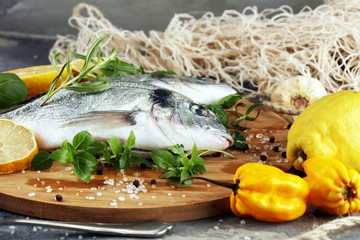 Delicious fresh fish. Fish with aromatic herbs, spices and vegetables - healthy food, diet or cooking concept.
