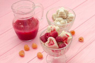 Homemade ice cream from milk and bananas with raspberry topping in glass ice-cream bowl on a pink background. Diet healthy dessert.