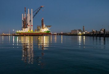 A wind turbine installation vessel in the port of Oostende at night