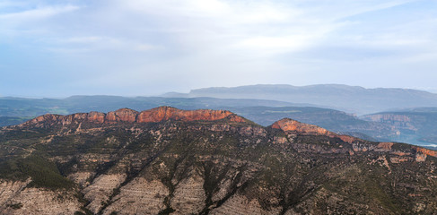Naklejka premium Aerial panorama of Serra de Mont-roig, Catalonia, Spain during sunrise taken from hot air balloon