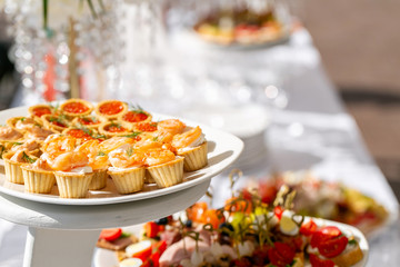 solemn banquet. Lot of glasses champagne or wine on the table in restaurant. buffet table with lots of delicious snacks. canapes, bruschetta, and little desserts on wooden plate board