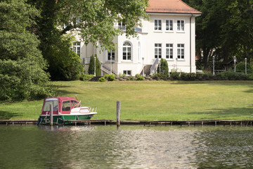 Fototapeta na wymiar Hotel am See mit Boot im Vordergrund