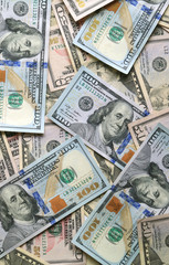 Top view of many United States one hundred dollar ($100) bills, vertical photo 