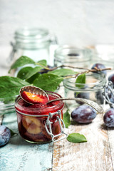Plums marmalade in jar Fruit jam wooden background