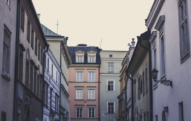 old classic beautiful houses facade in old city narrow street in autumn foggy weather