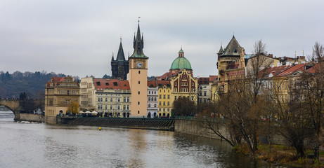 Fototapeta premium View of the left bank of the Vltava River in Prague, Old place, Old Town water tower. The tower with an elongated pointed spire and narrow Gothic turrets. Near the Old Town Bridge Tower. 