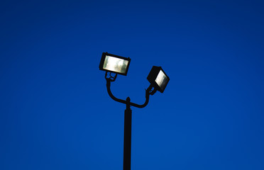 Silhouette of street lamp with bulbs on