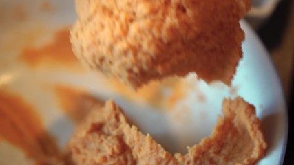 Scooping a spoonful of mashed sweet potatoes