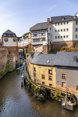 Fototapeta na wymiar waterfall in the city center of Saarburg, Germany surrounded by houses on a hill