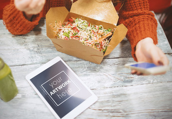 Woman Using Smartphone and Tablet While Eating Takeout Mockup - Powered by Adobe