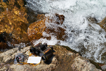 Picture of vintage binoculars, bank card and compass.