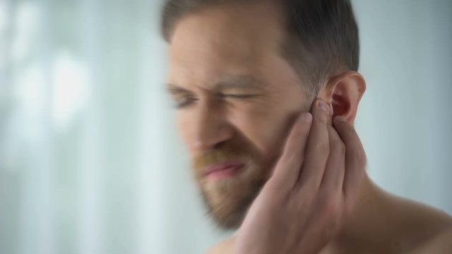 Man feels pain in middle ear, meningitis and hearing loss, inflammation, closeup