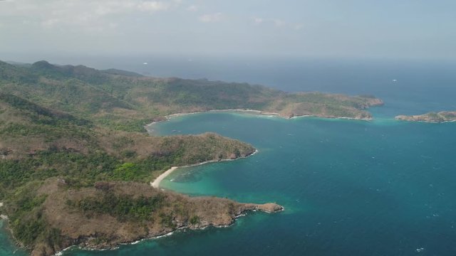 Aerial view of coast with beaches, lagoons and coral reefs. Neela cove, Limbones. Coast ocean with tropical beach, turquoise water. Tropical landscape in Asia. Philippines, Luzon.