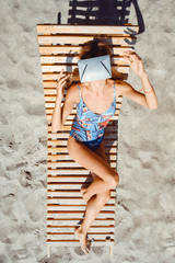 Young woman reaching out in VR glasses on beach