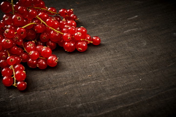 delicious and juicy red currant on an old black wooden table