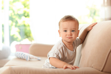 Adorable little baby on sofa at home