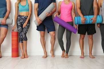 Group of young people waiting for yoga class - obrazy, fototapety, plakaty