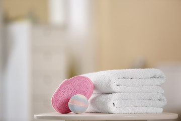 Clean towels and toiletries on table against blurred background