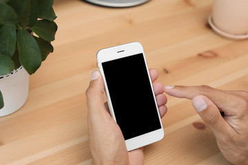 Man with modern mobile phone at table, closeup