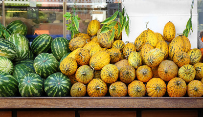 Fruit market with many ripe melons and watermelons