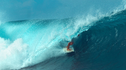 CLOSE UP: Unrecognizable male tourist surfing a cool turquoise barrel wave.