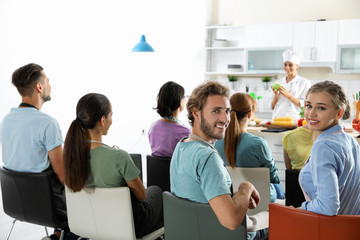 Group of people and female chef at cooking classes