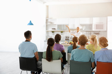 Group of people and female chef at cooking classes