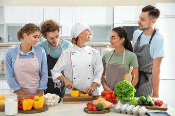 Group of people and female chef at cooking classes