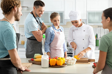 Group of people and female chef at cooking classes