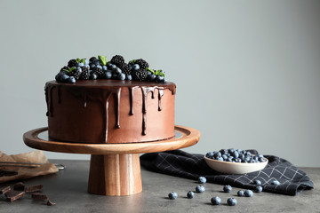 Fresh delicious homemade chocolate cake with berries on table against gray background. Space for text