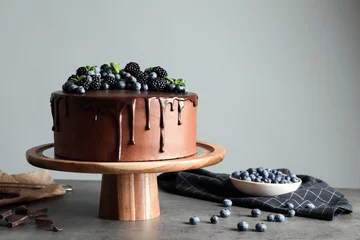  Fresh delicious homemade chocolate cake with berries on table against gray background. Space for text © New Africa
