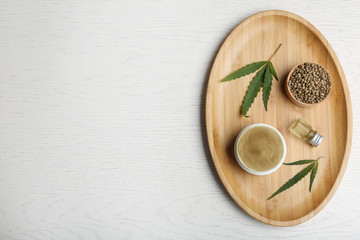 Flat lay composition with hemp lotion and space for text on white wooden background