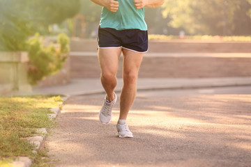Young man running in park on sunny day