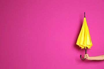 Woman holding beautiful umbrella on color background with space for design © New Africa