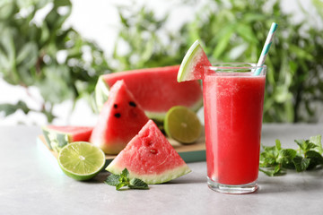 Tasty summer watermelon drink in glass and fresh fruits on table