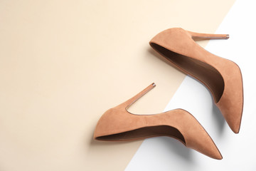 Pair of beautiful shoes and space for text on color background, top view