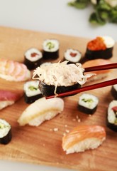 Gunkan Sushi with Chopsticks and Sushi Plate in Background