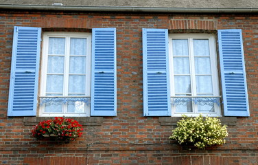Fototapeta na wymiar ville de Francheville, fenêtres et volets bleus, fleurs accrochées au mur, département de l'Eure, Normandie, France