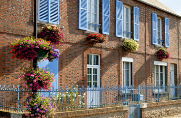Fototapeta na wymiar ville de Francheville, porte et volets bleus, fleurs accrochées au mur, barrière bleue, département de l'Eure, Normandie, France