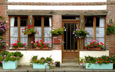 Fototapeta na wymiar ville fleurie de Francheville, façade fleurie et balconières vertes, département de l'Eure, Normandie, France