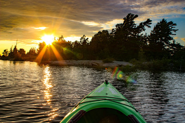 Kayak on a lake at a fiery sunset. Muskoka region Ontario