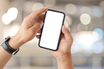 Man's hand shows mobile smartphone with white screen over blurred background.