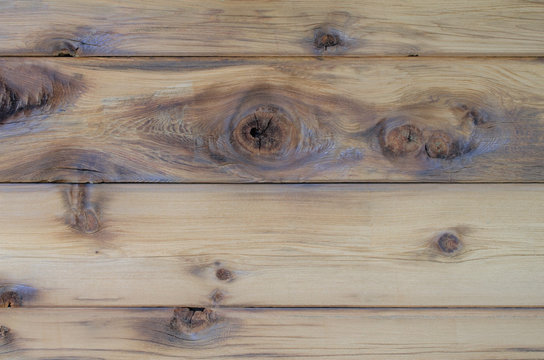 Natural wood cedar siding with knots, texture and design. Beautiful rustic indoor or outdoor background. Unpainted natural colored cedar wood panels.