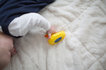Fototapeta na wymiar baby's hand holding rubber duck