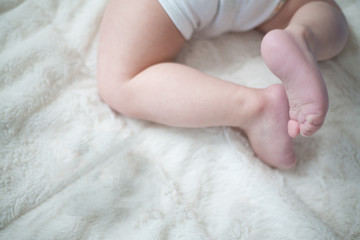 baby's legs and bottom on white blanket